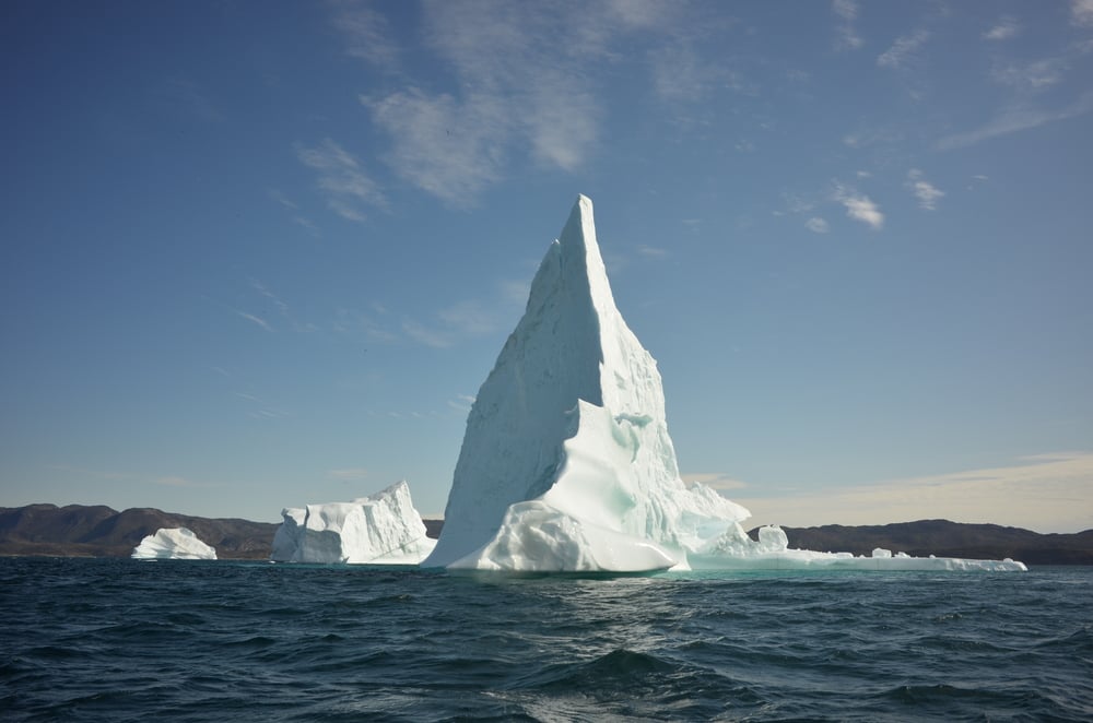 Tall iceberg floats in open water